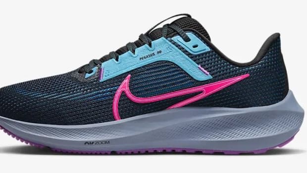 Side view of a black and pink Nike running shoe.